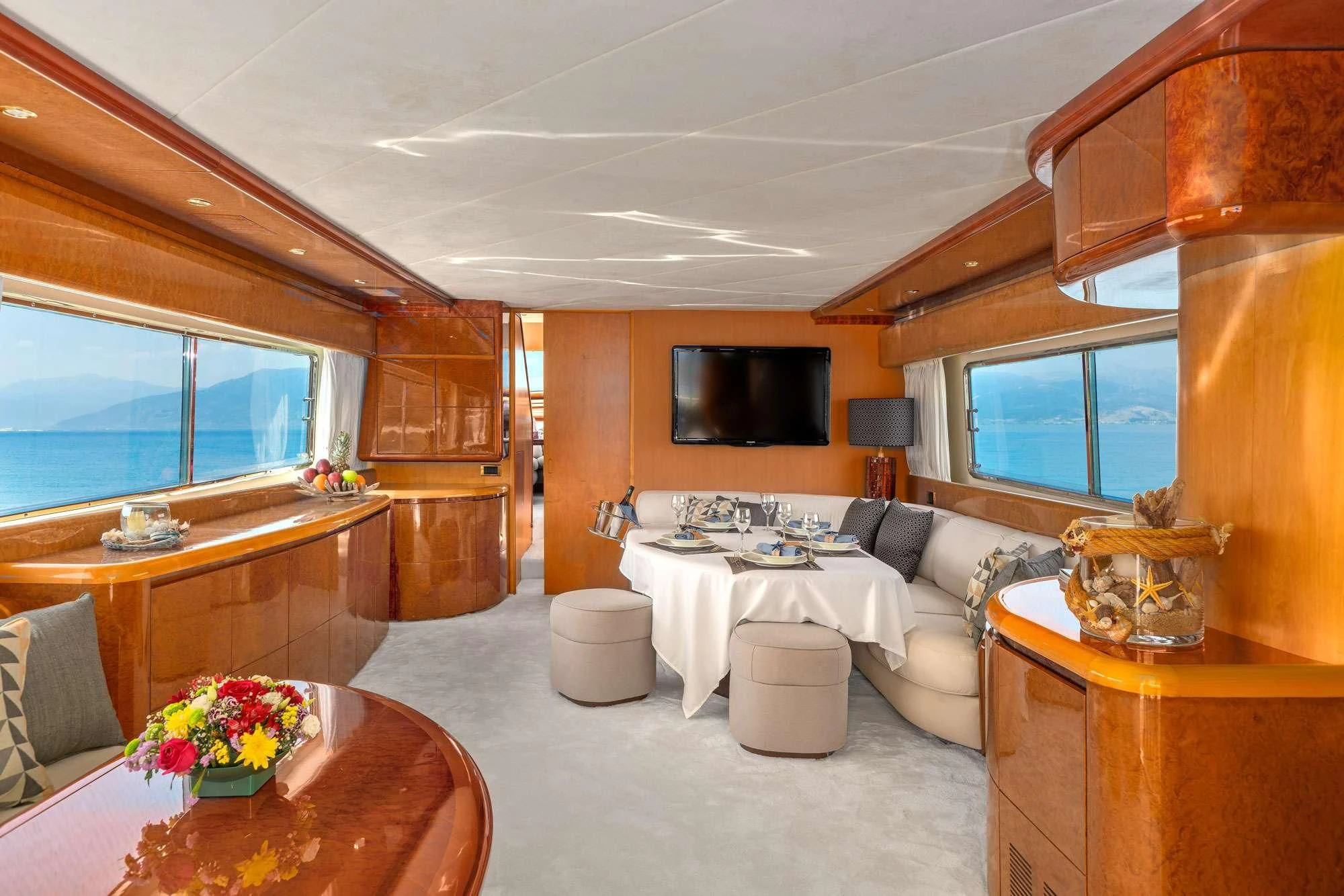 a living room with a table and couches aboard ALANDINI Yacht for Sale