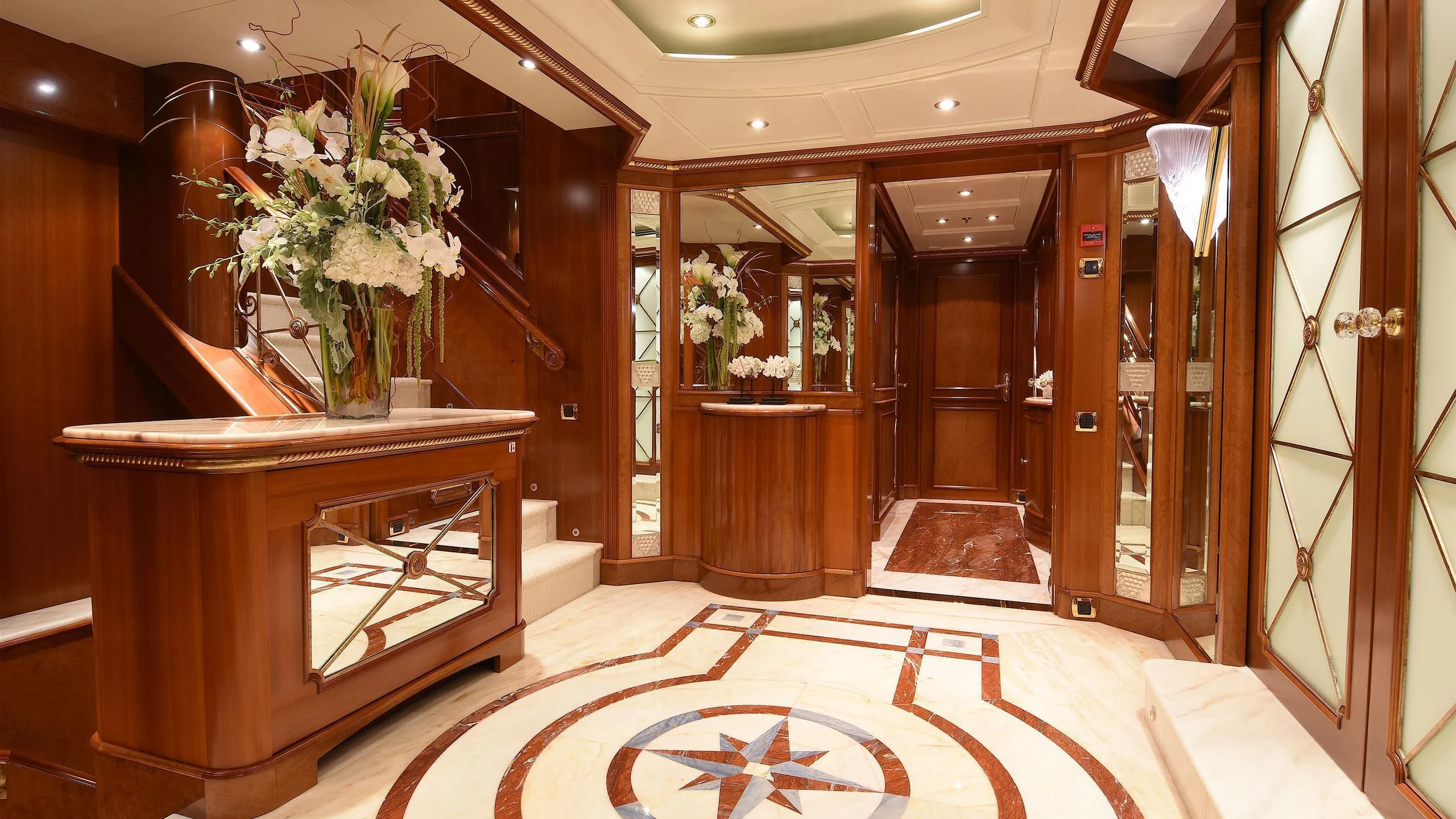 a room with a table and vases with flowers aboard NEXT CHAPTER Yacht for Sale