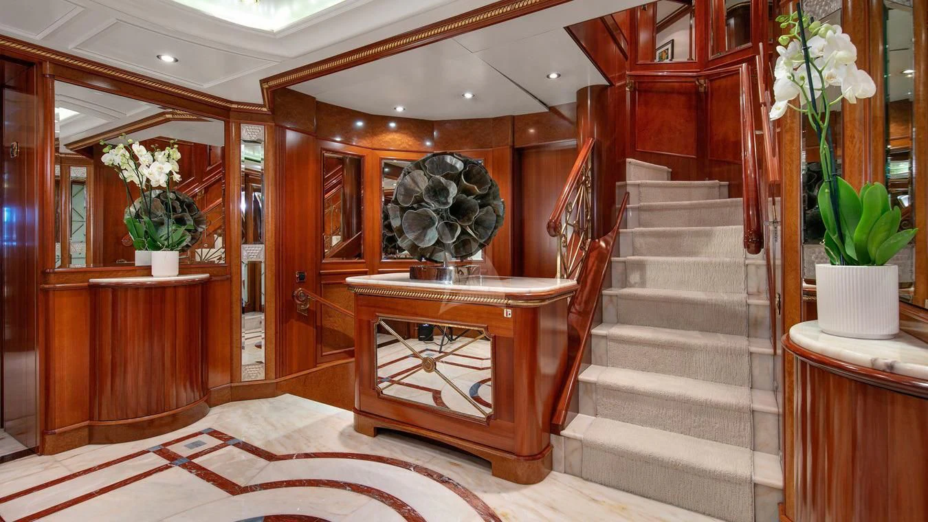 a room with a staircase and potted plants aboard NEXT CHAPTER Yacht for Sale