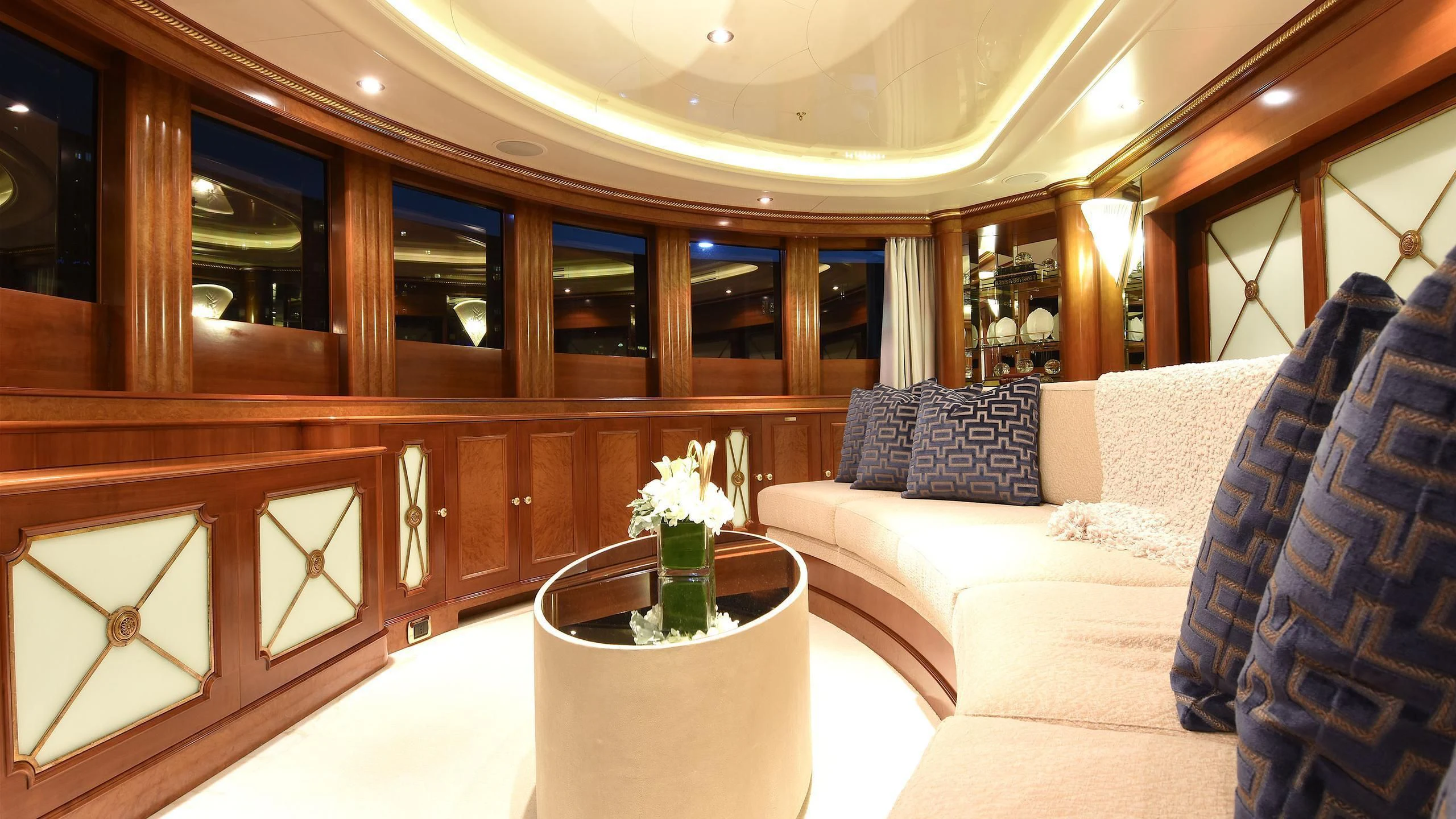 a room with a couch and a table with a vase of flowers aboard NEXT CHAPTER Yacht for Sale