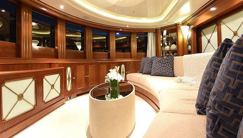 a room with a couch and a table with a vase of flowers aboard NEXT CHAPTER Yacht for Sale