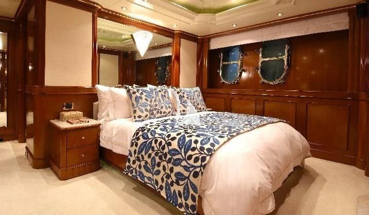 a bed with a blue and white comforter aboard NEXT CHAPTER Yacht for Sale