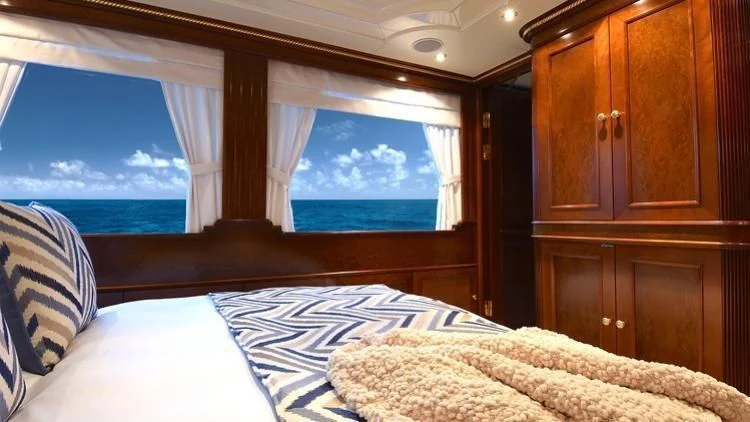 a room with a bed and a large window aboard NEXT CHAPTER Yacht for Sale