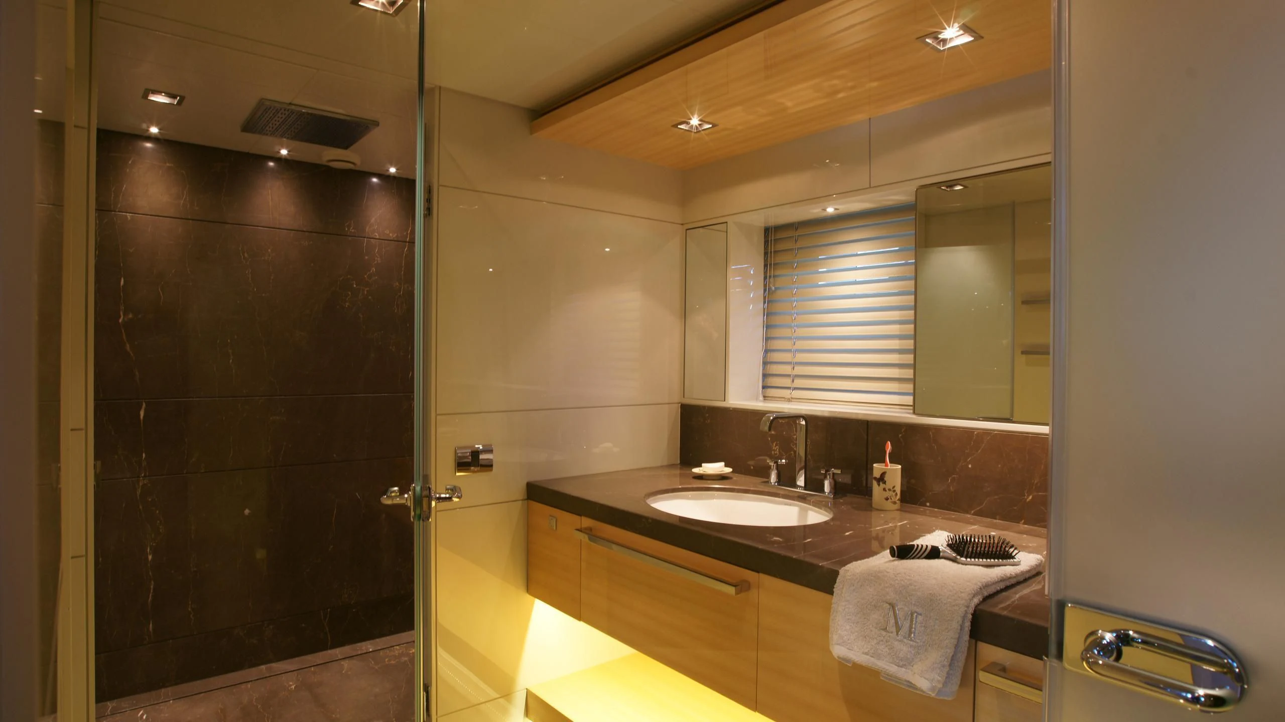 a bathroom with a countertop sink and a shower unit aboard OCEAN CLUB Yacht for Sale