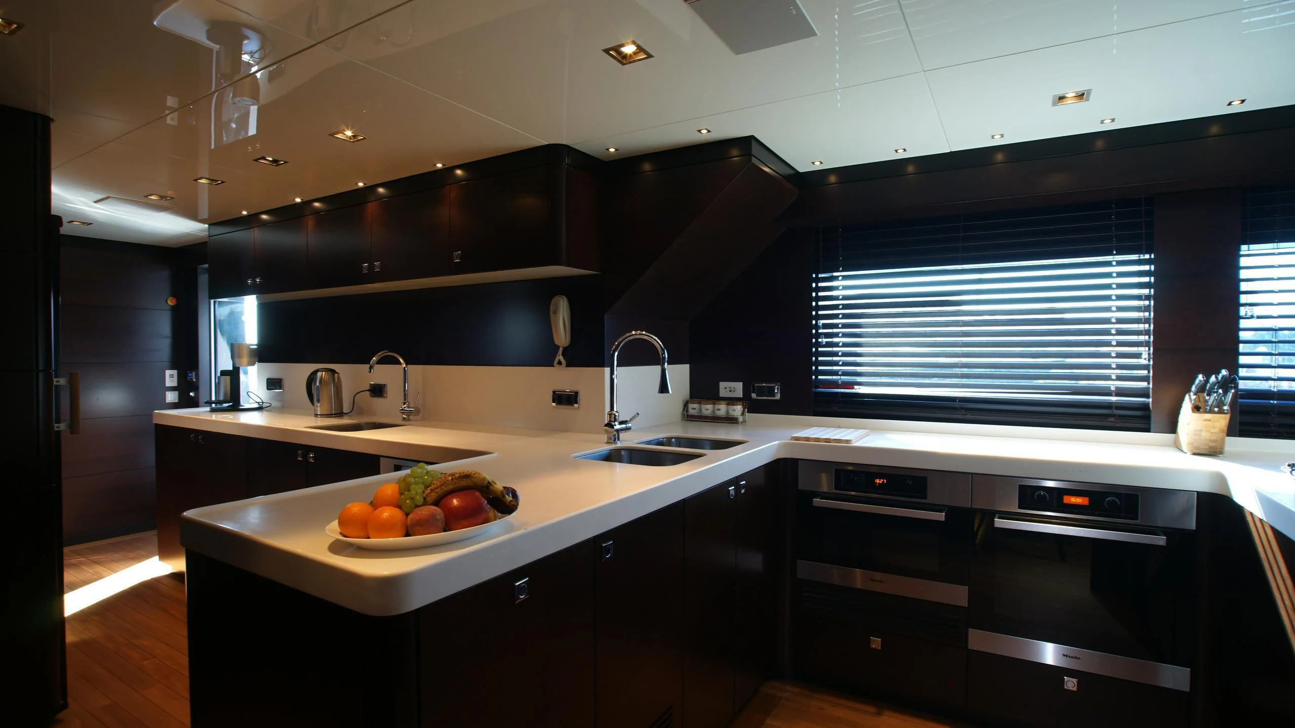 a kitchen with black cabinets aboard OCEAN CLUB Yacht for Sale