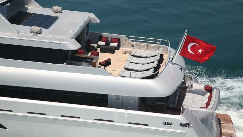 a boat with a flag on the front aboard OCEAN CLUB Yacht for Sale