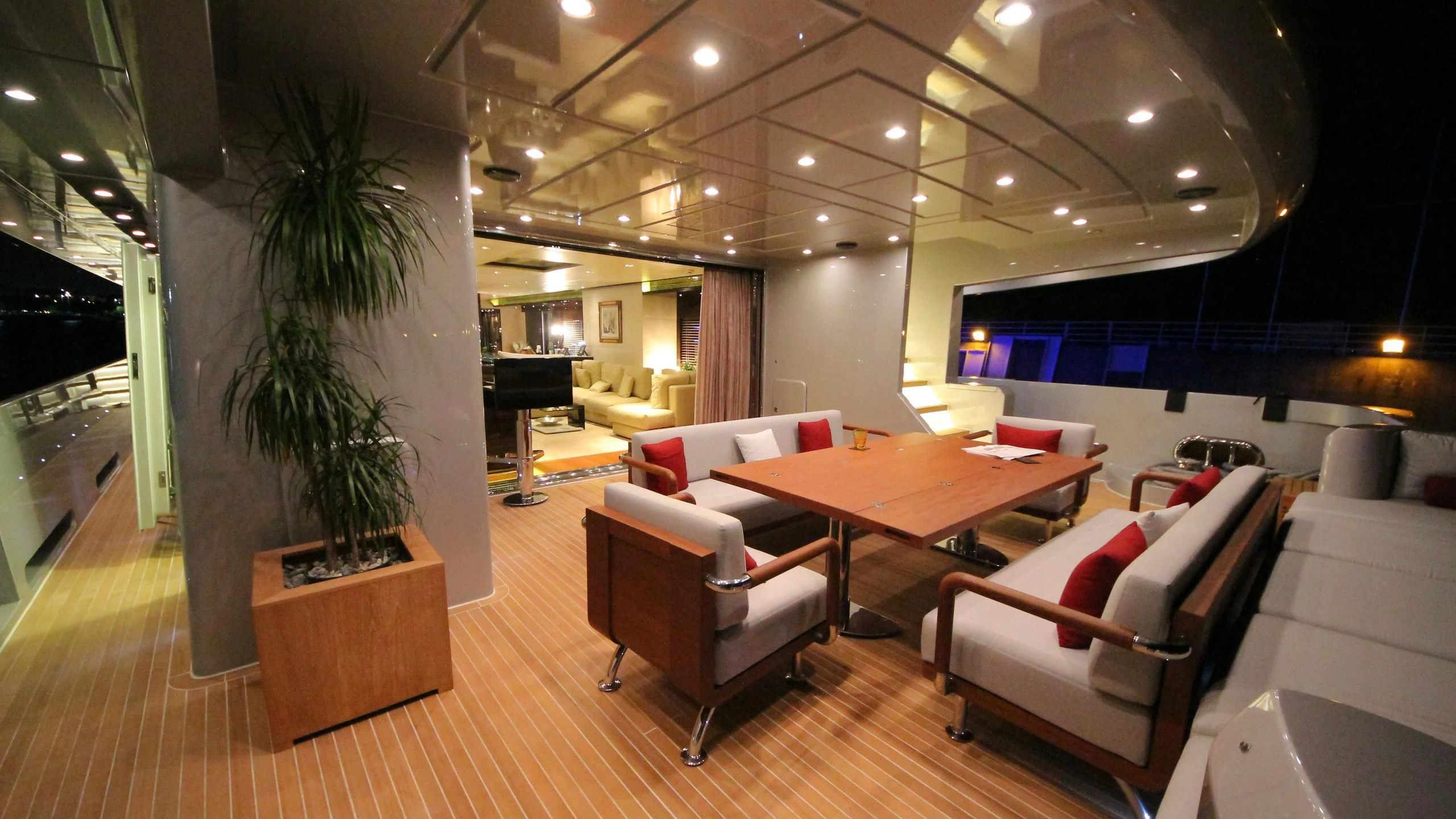 a room with a table chairs and a plant in it aboard OCEAN CLUB Yacht for Sale