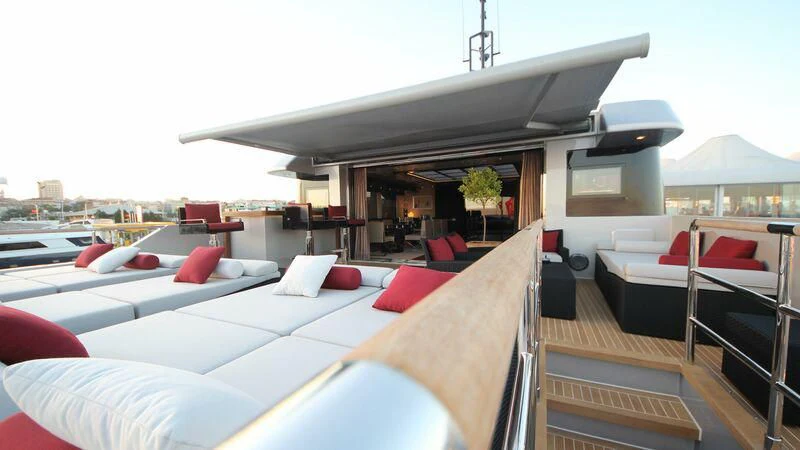 a room with a bed and a table and chairs aboard OCEAN CLUB Yacht for Sale