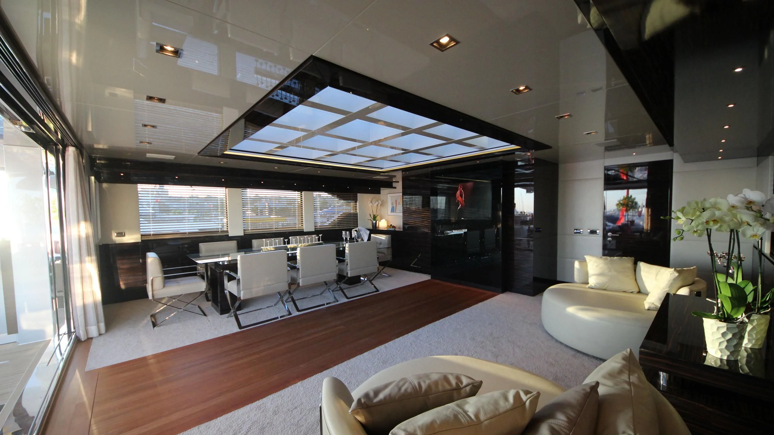 a room with a large window and a large table with chairs and a large window aboard OCEAN CLUB Yacht for Sale