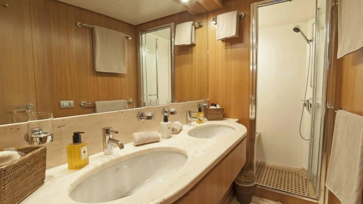 a bathroom with two sinks and a shower curtain aboard FASTER Yacht for Sale