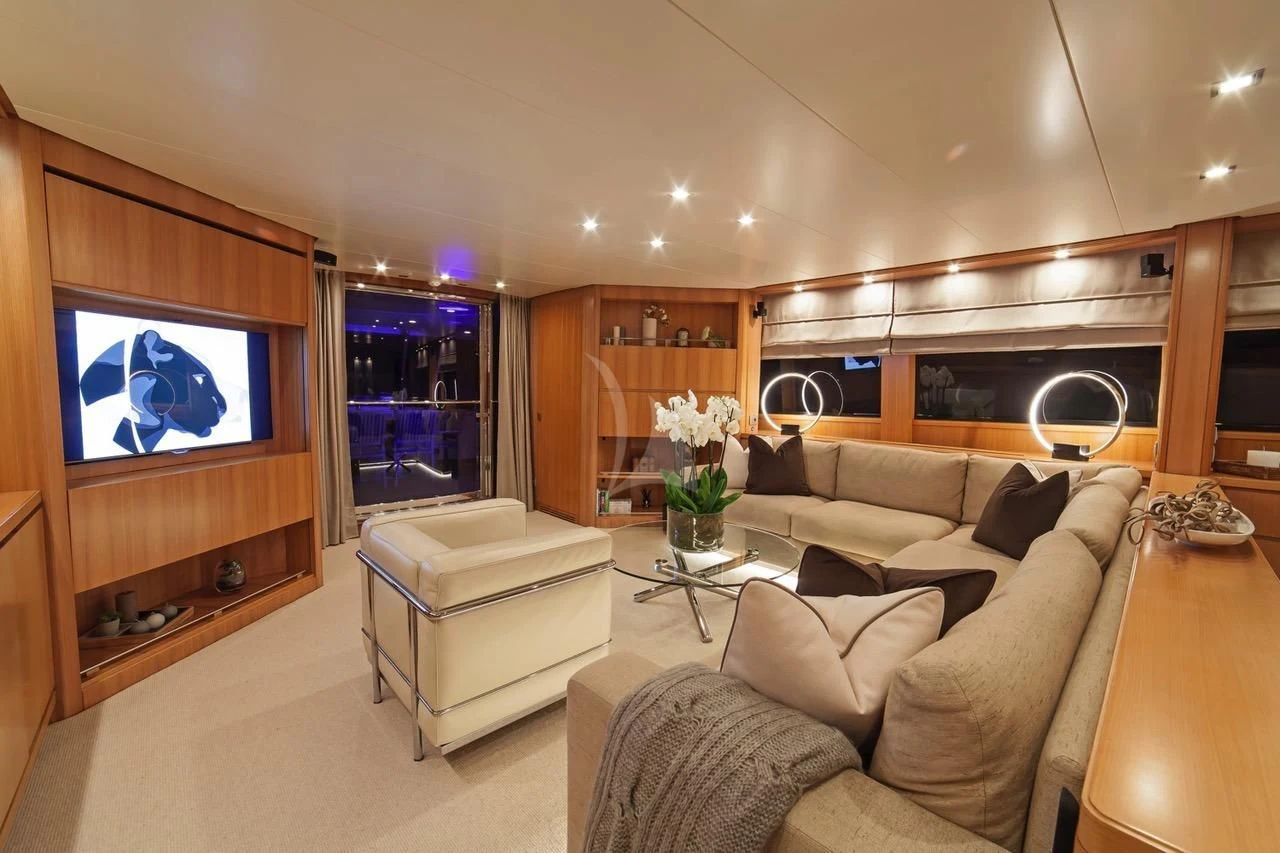 a living room with a large television aboard FASTER Yacht for Sale