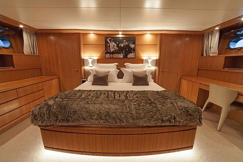 a bed with a black comforter aboard FASTER Yacht for Sale