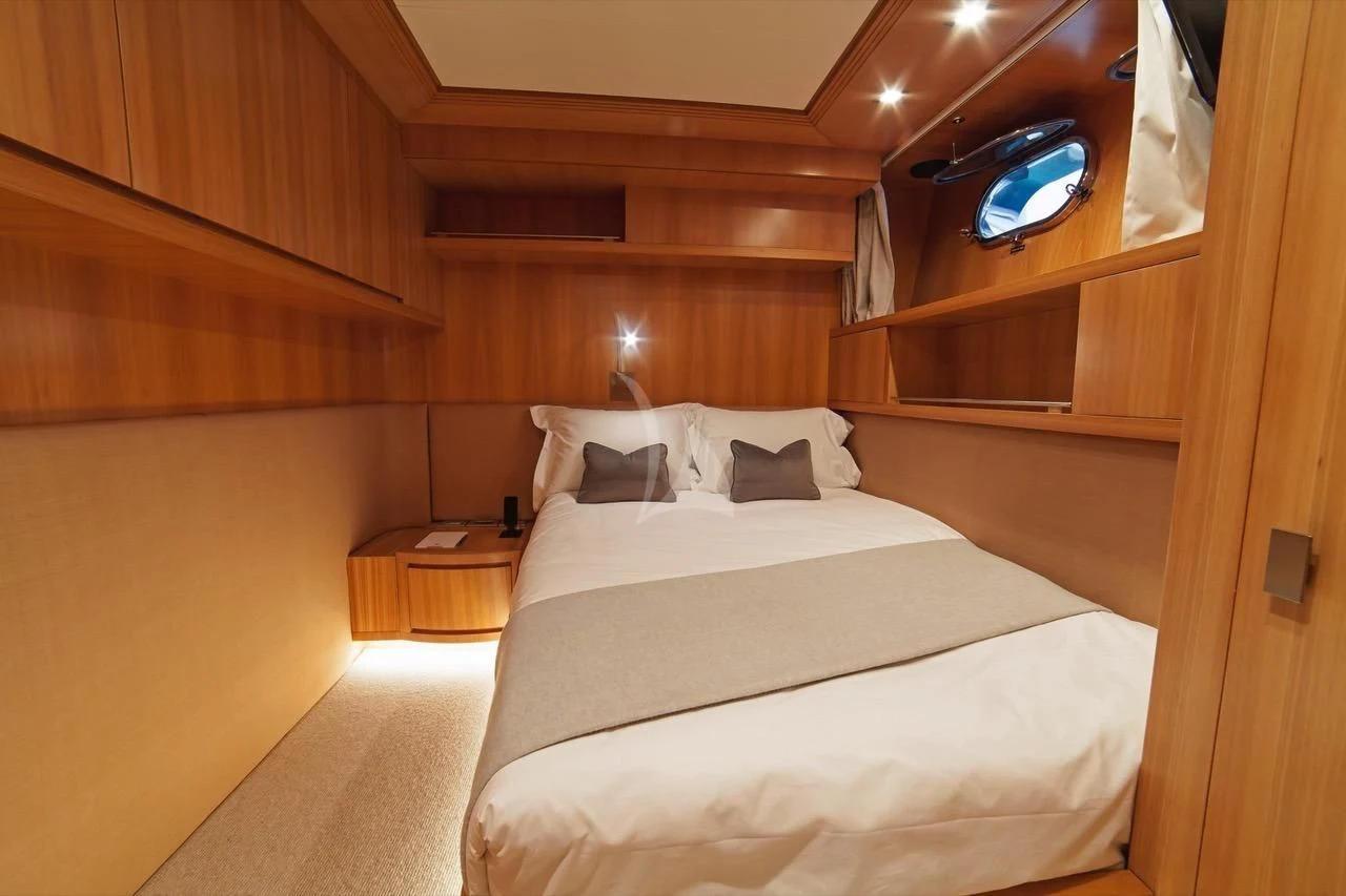 a room with a bed and a desk aboard FASTER Yacht for Sale