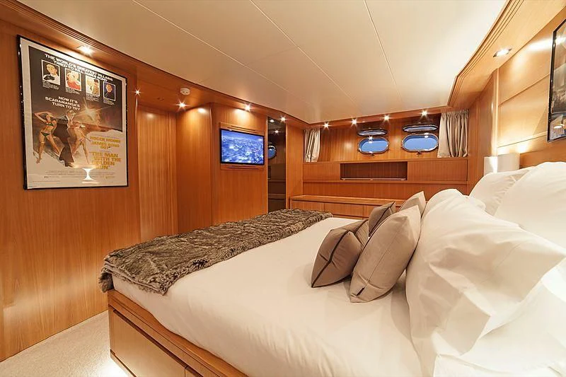 a room with a bed and a television aboard FASTER Yacht for Sale