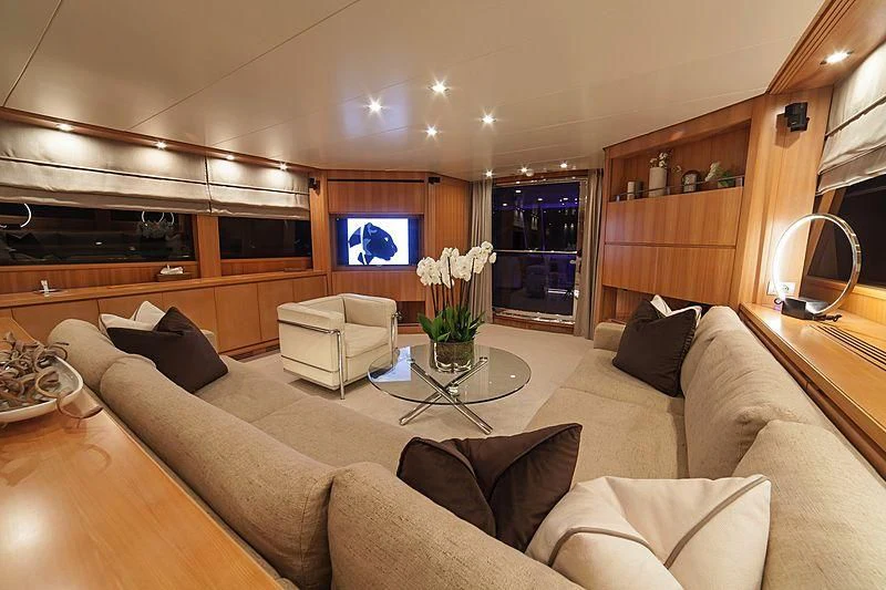 a living room with a large sofa aboard FASTER Yacht for Sale