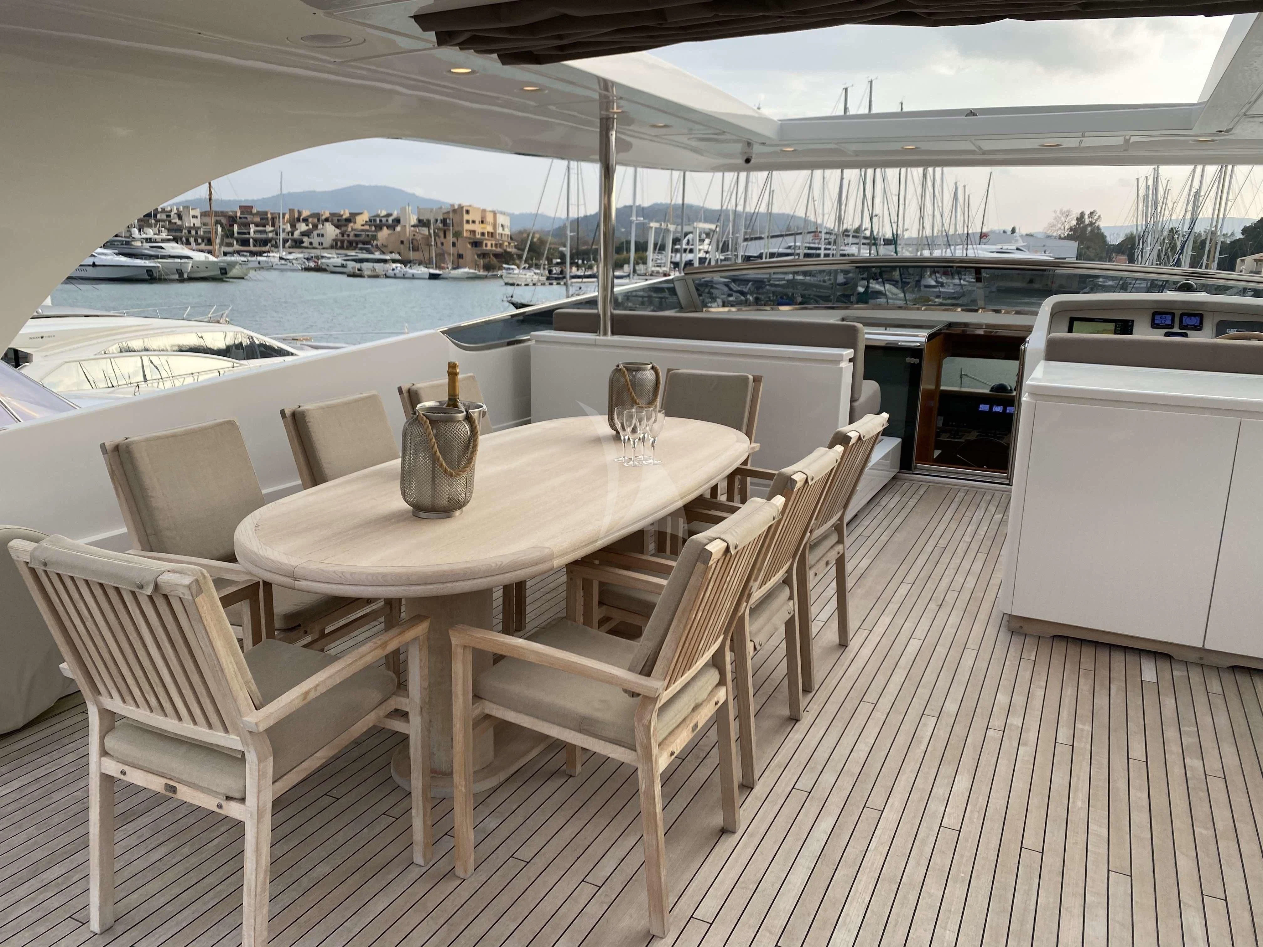 a table and chairs on a deck aboard FASTER Yacht for Sale