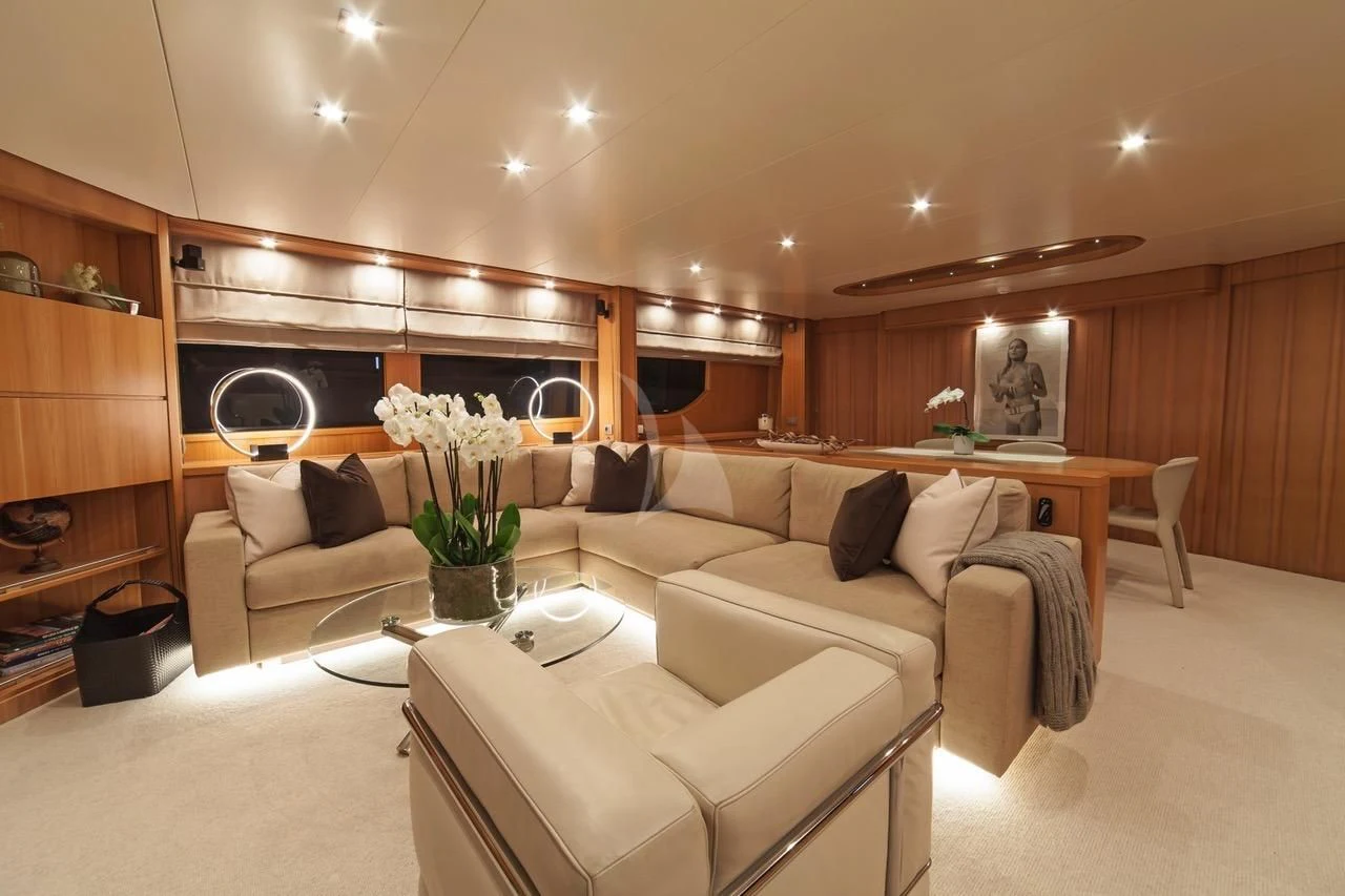 a living room with a couch and a coffee table aboard FASTER Yacht for Sale