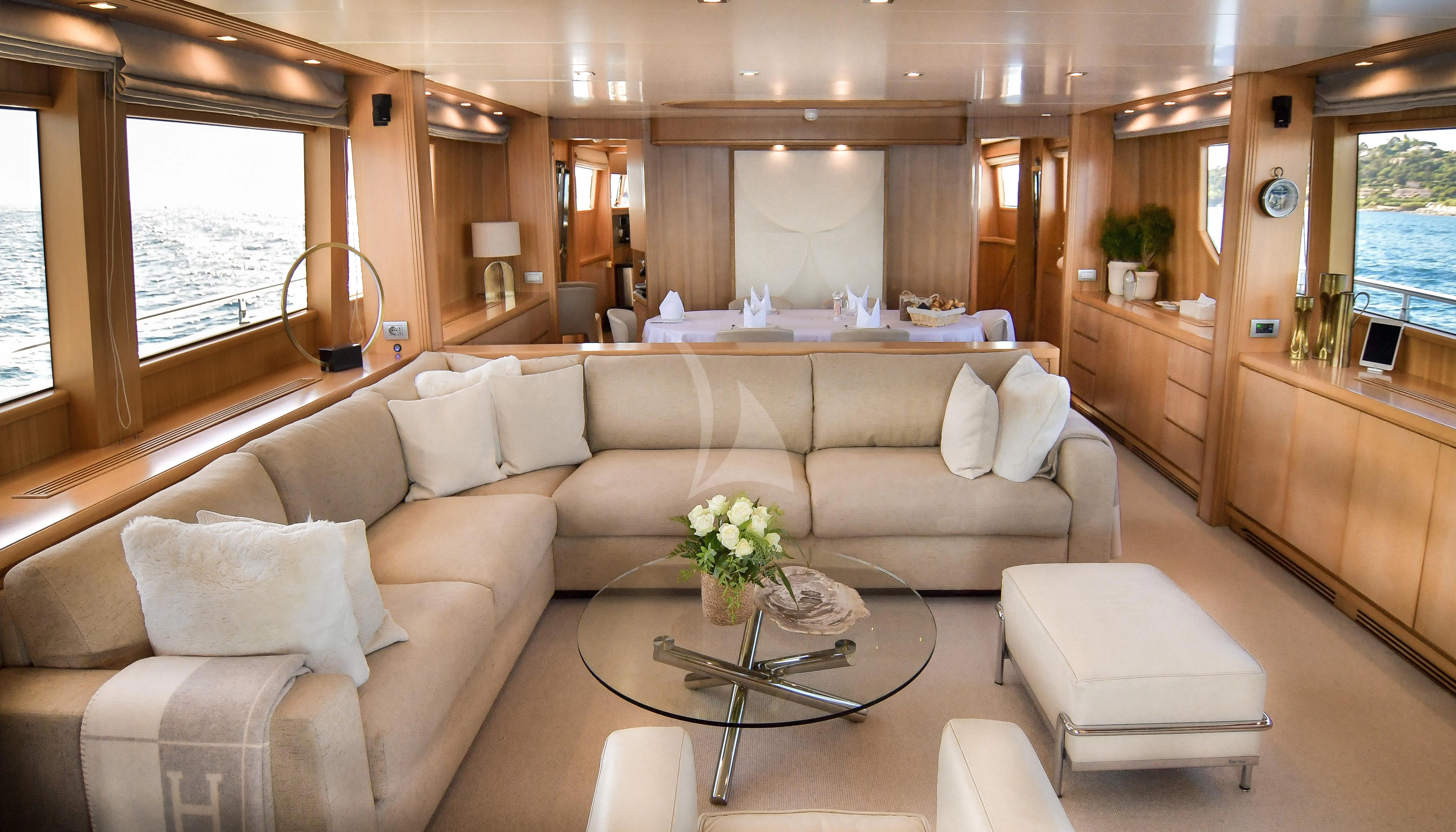 a living room with a couch and a coffee table aboard FASTER Yacht for Sale
