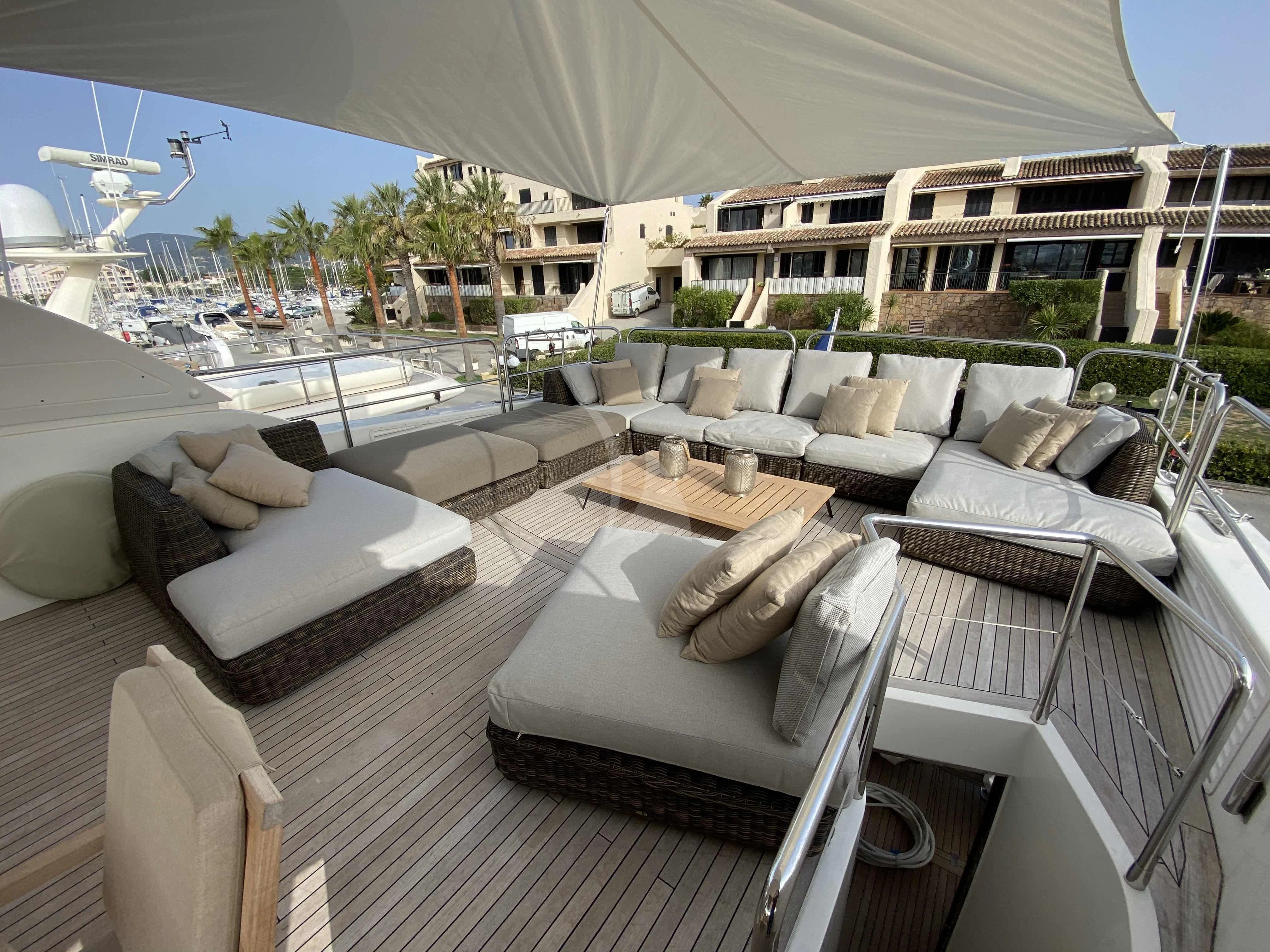 a deck with a couch and chairs aboard FASTER Yacht for Sale