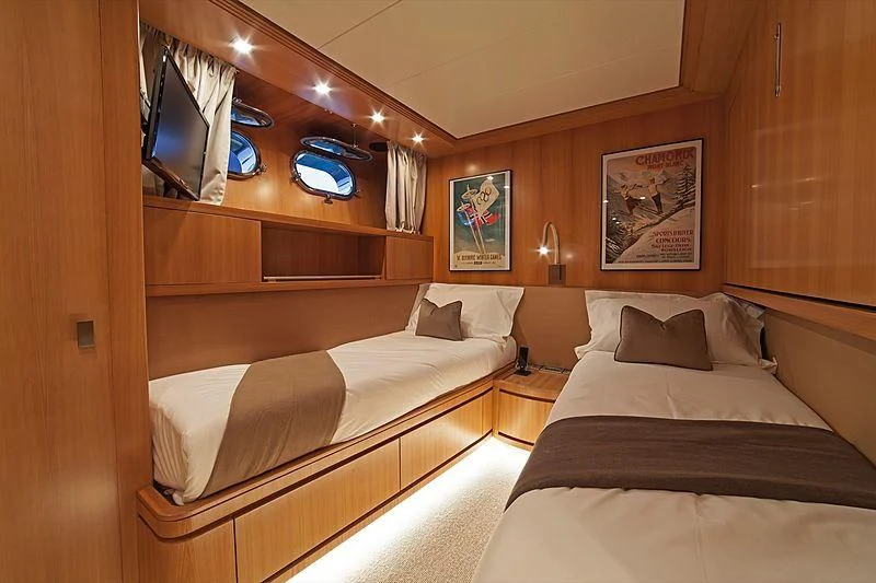 a room with a bed and a television aboard FASTER Yacht for Sale