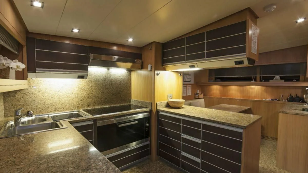 a kitchen with wooden cabinets aboard FASTER Yacht for Sale