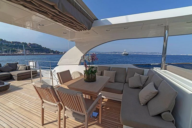 a patio with a table and chairs on it aboard FASTER Yacht for Sale