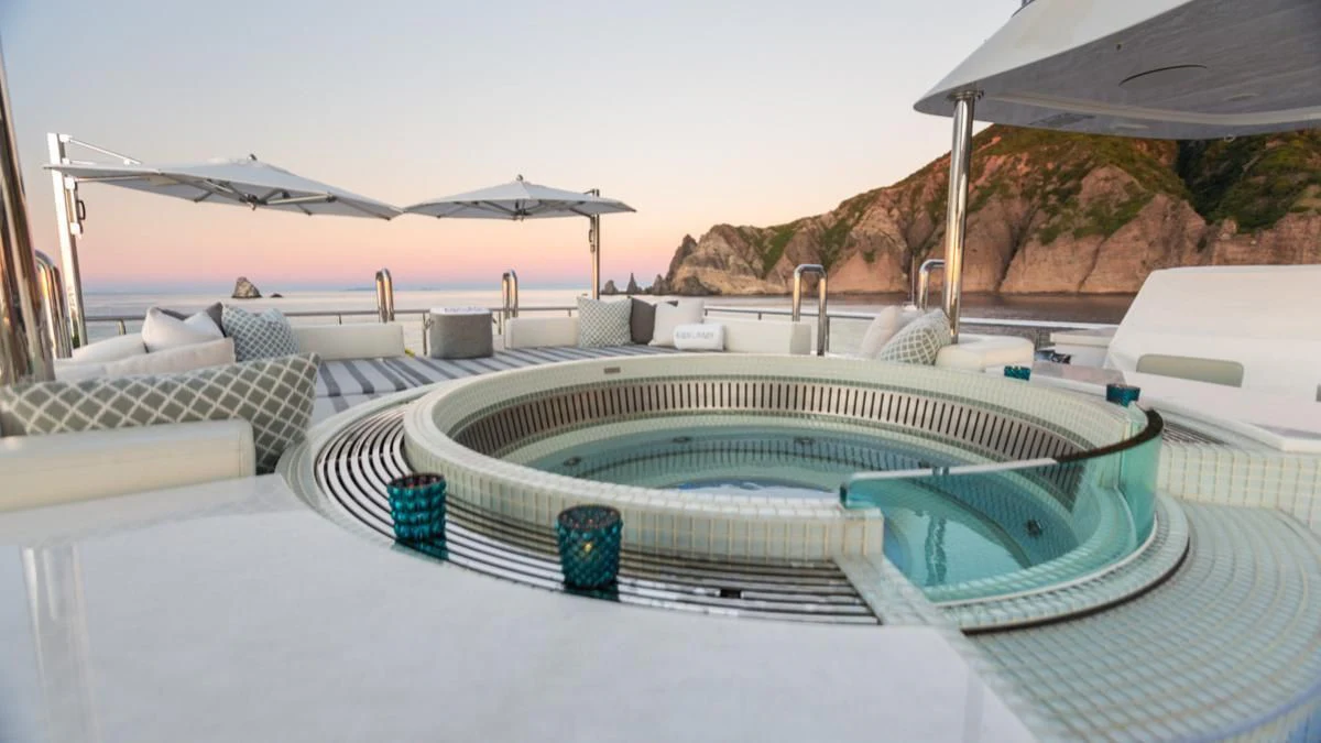 a pool with a deck and a building in the background aboard KING BABY Yacht for Sale