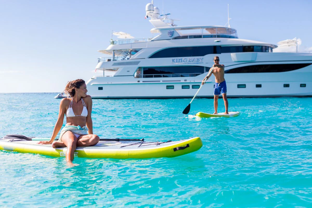 a man and woman on a paddle board in the water aboard KING BABY Yacht for Sale