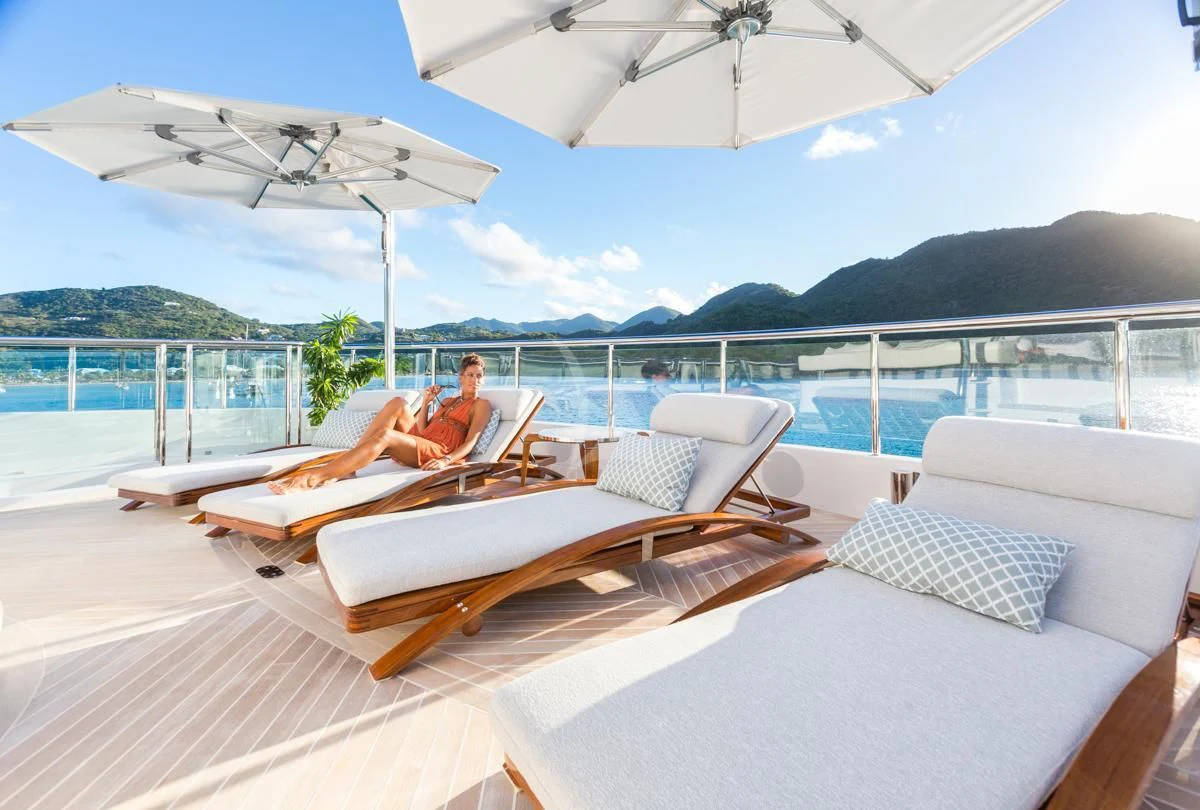 a couple of people lounging on a lounge chair on a boat aboard KING BABY Yacht for Sale