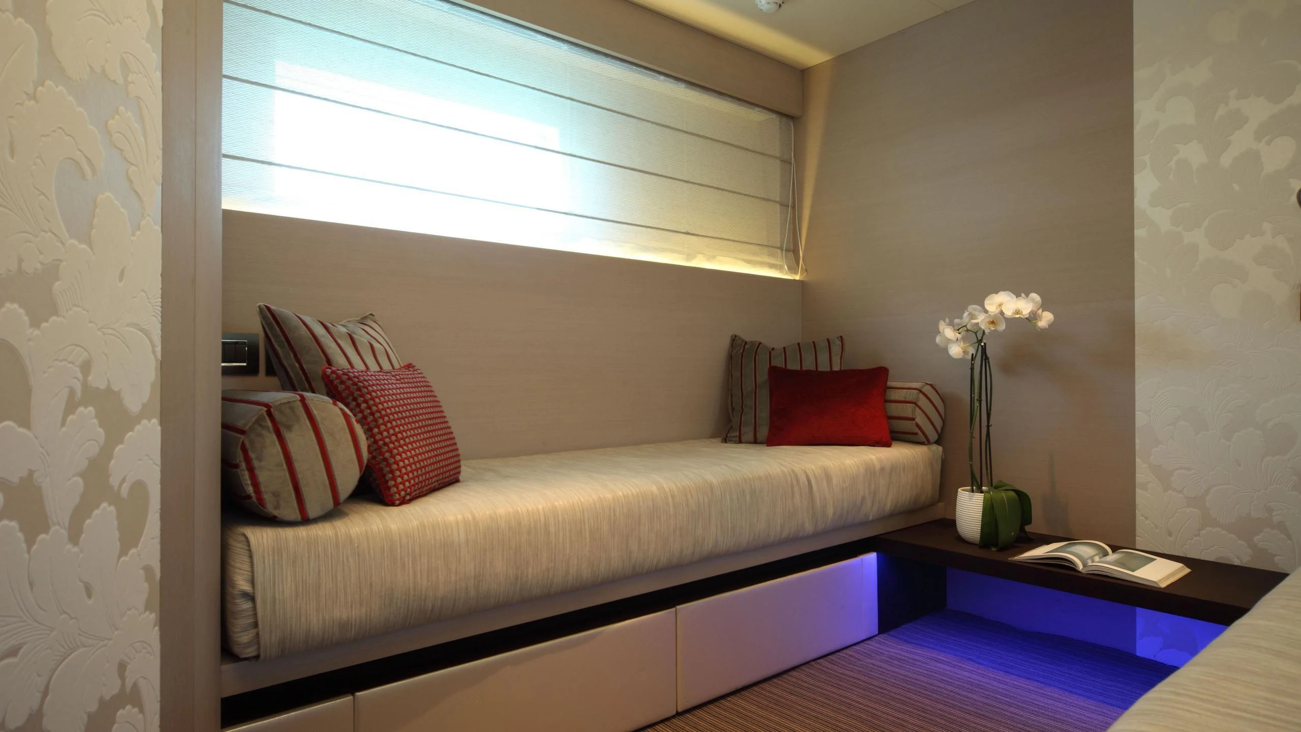 a couch with pillows and a vase of flowers on it aboard AURORA Yacht for Sale
