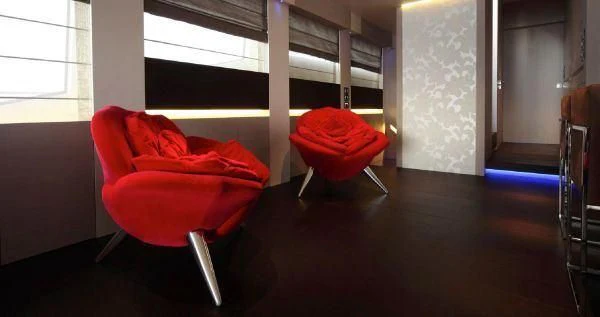 a red chair in a room aboard AURORA Yacht for Sale