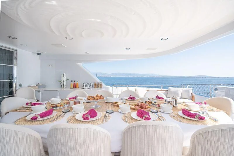 a dining room with a large white table and chairs aboard TITIAN PEARL Yacht for Sale