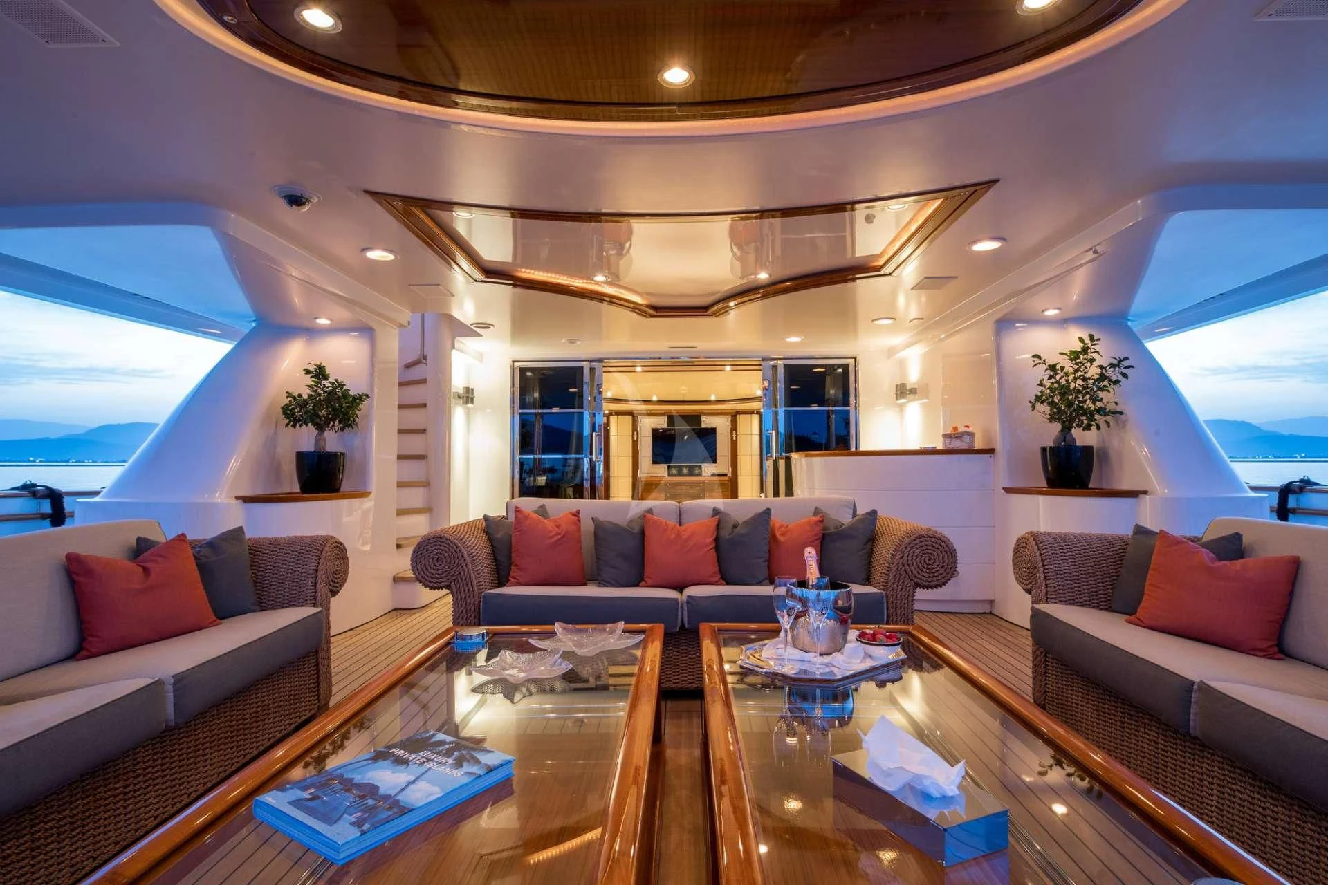 a living room with a large glass table and a large window aboard TITIAN PEARL Yacht for Sale