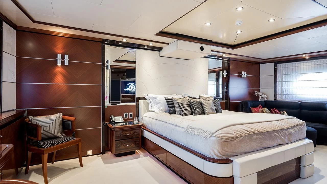 a bedroom with a bed and a chair aboard TITIAN PEARL Yacht for Sale