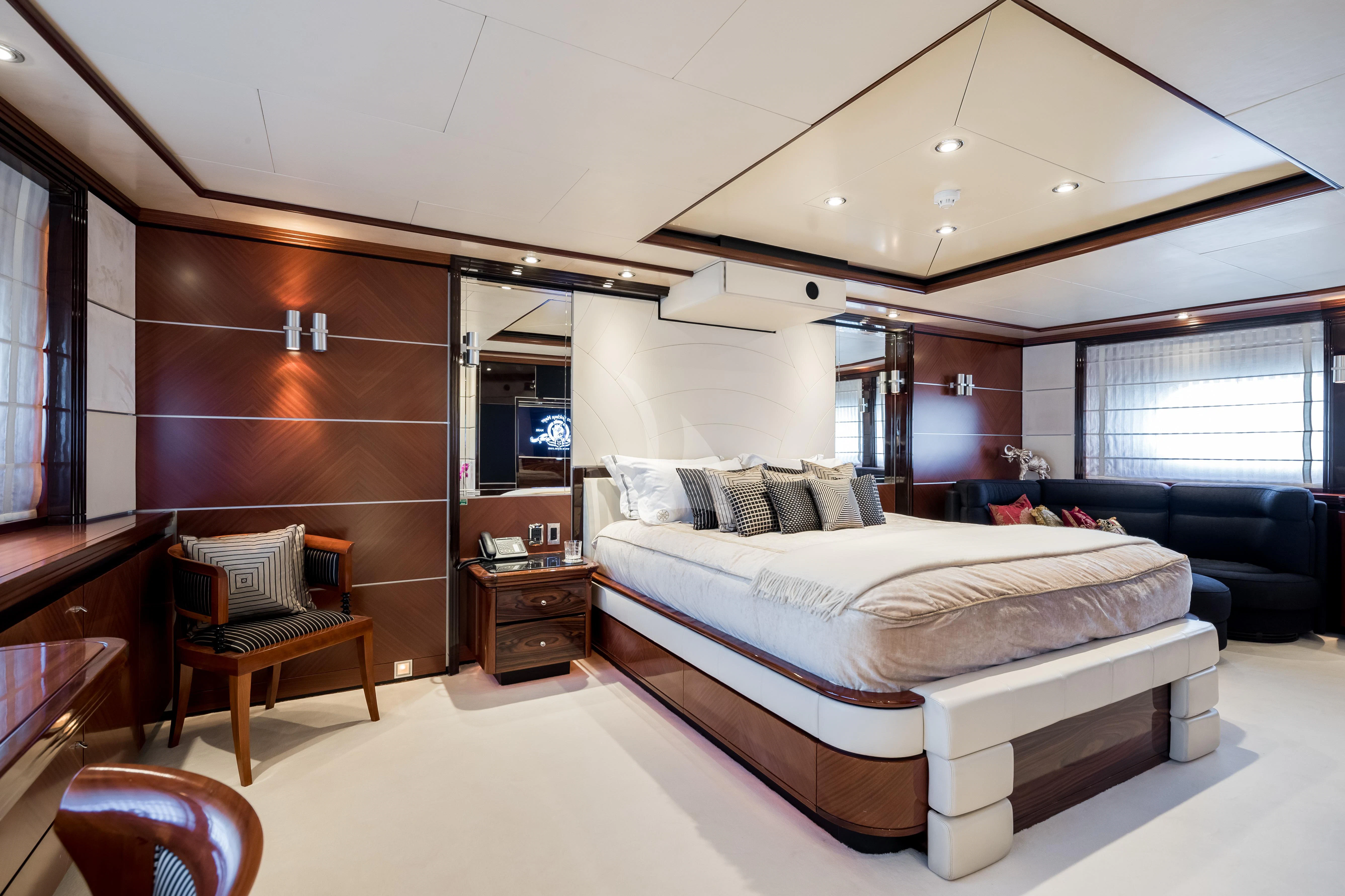 a bedroom with a bed and a couch aboard TITIAN PEARL Yacht for Sale