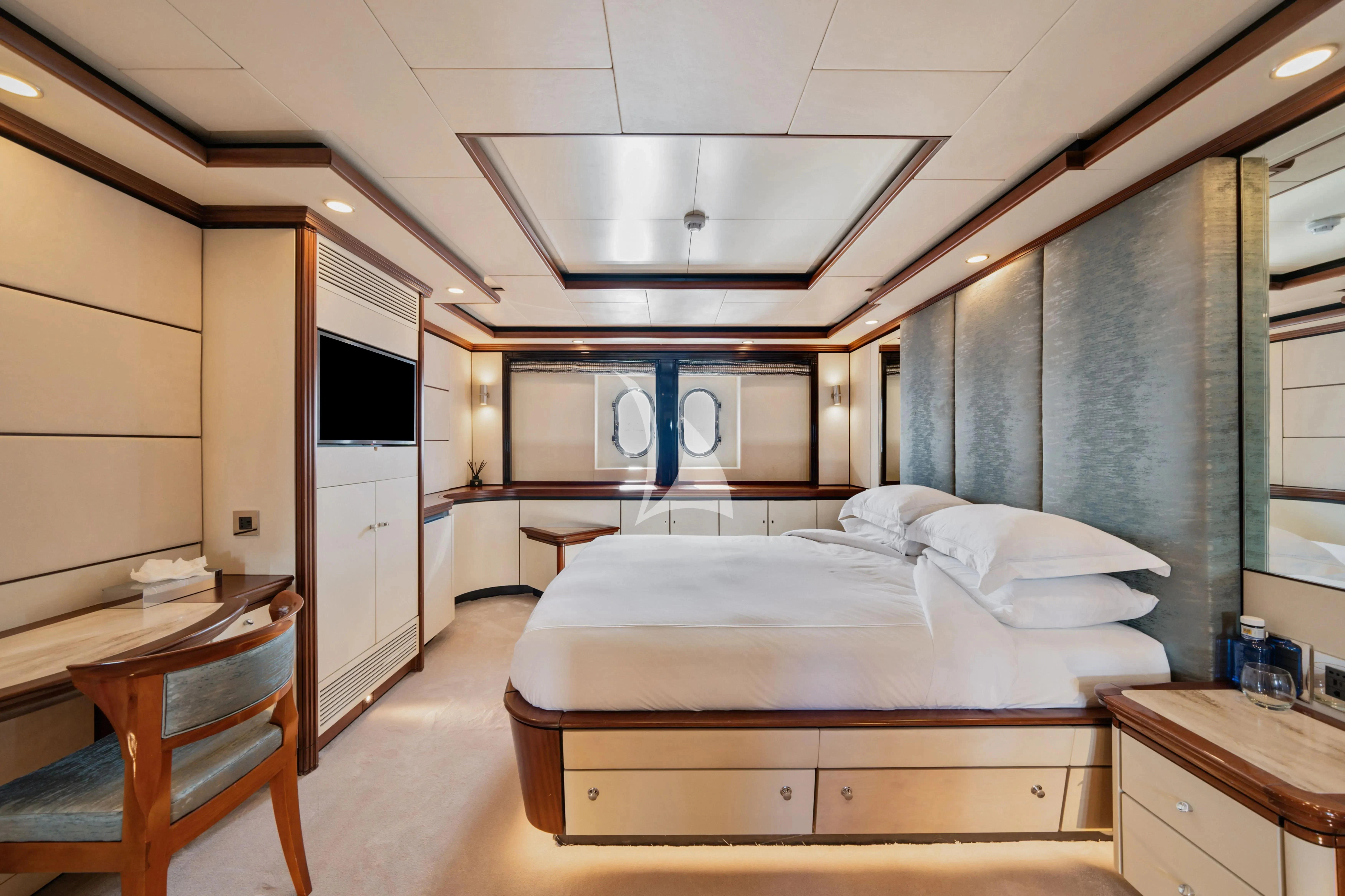 a room with a bed and desk aboard TITIAN PEARL Yacht for Sale