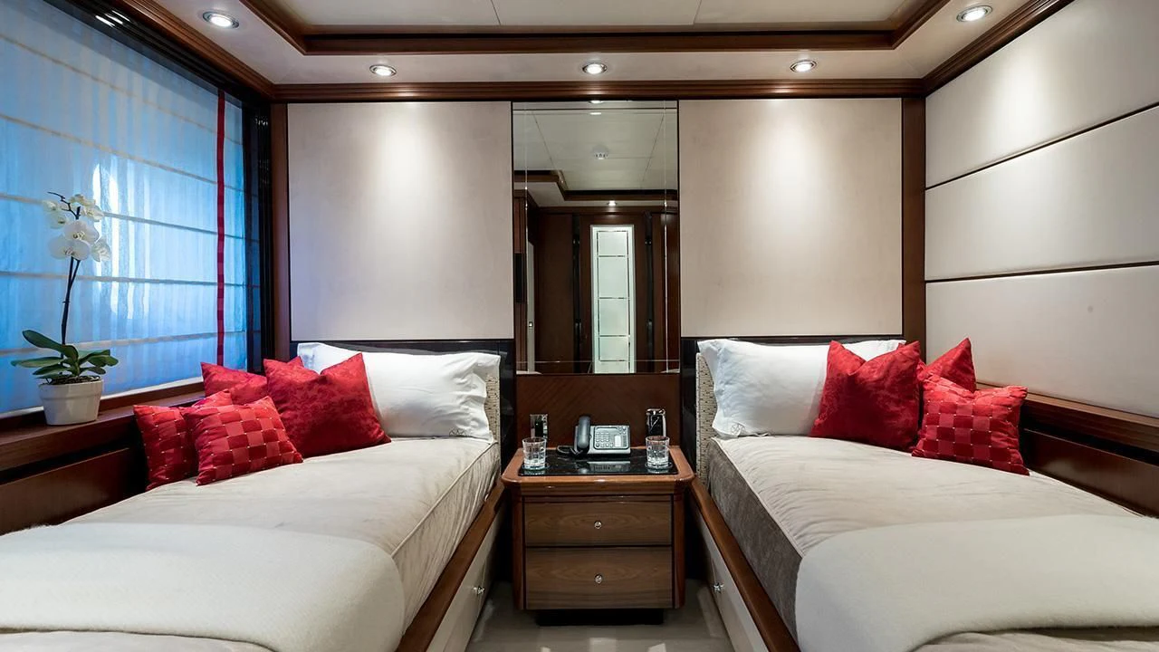 a room with a bed and a desk aboard TITIAN PEARL Yacht for Sale