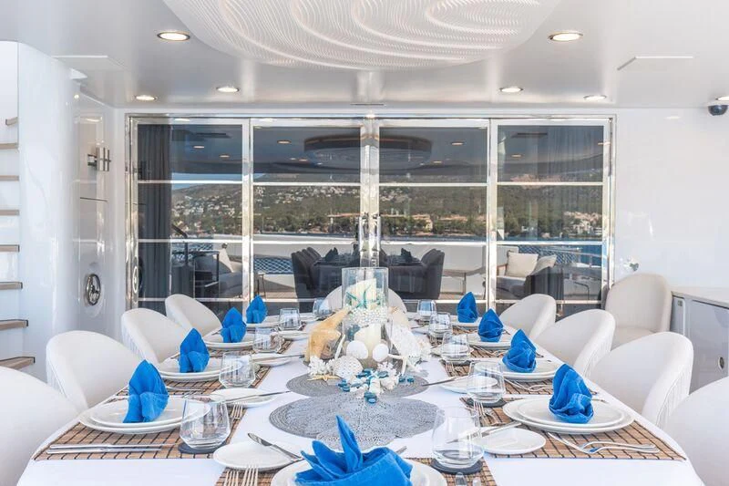 a room with a table chairs and a large window aboard TITIAN PEARL Yacht for Sale