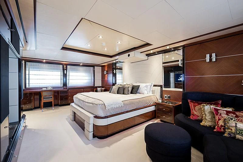 a bedroom with a bed and a couch aboard TITIAN PEARL Yacht for Sale