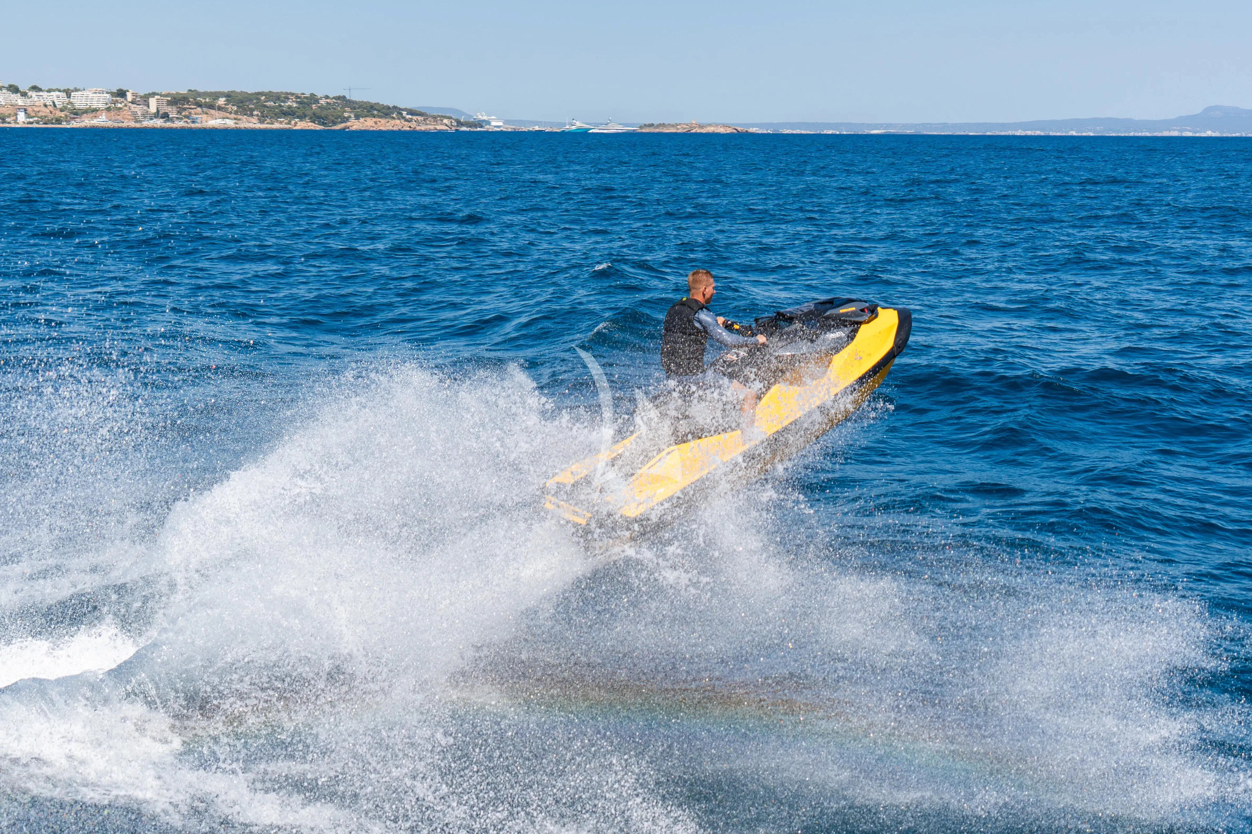 a person riding a surfboard aboard TITIAN PEARL Yacht for Sale