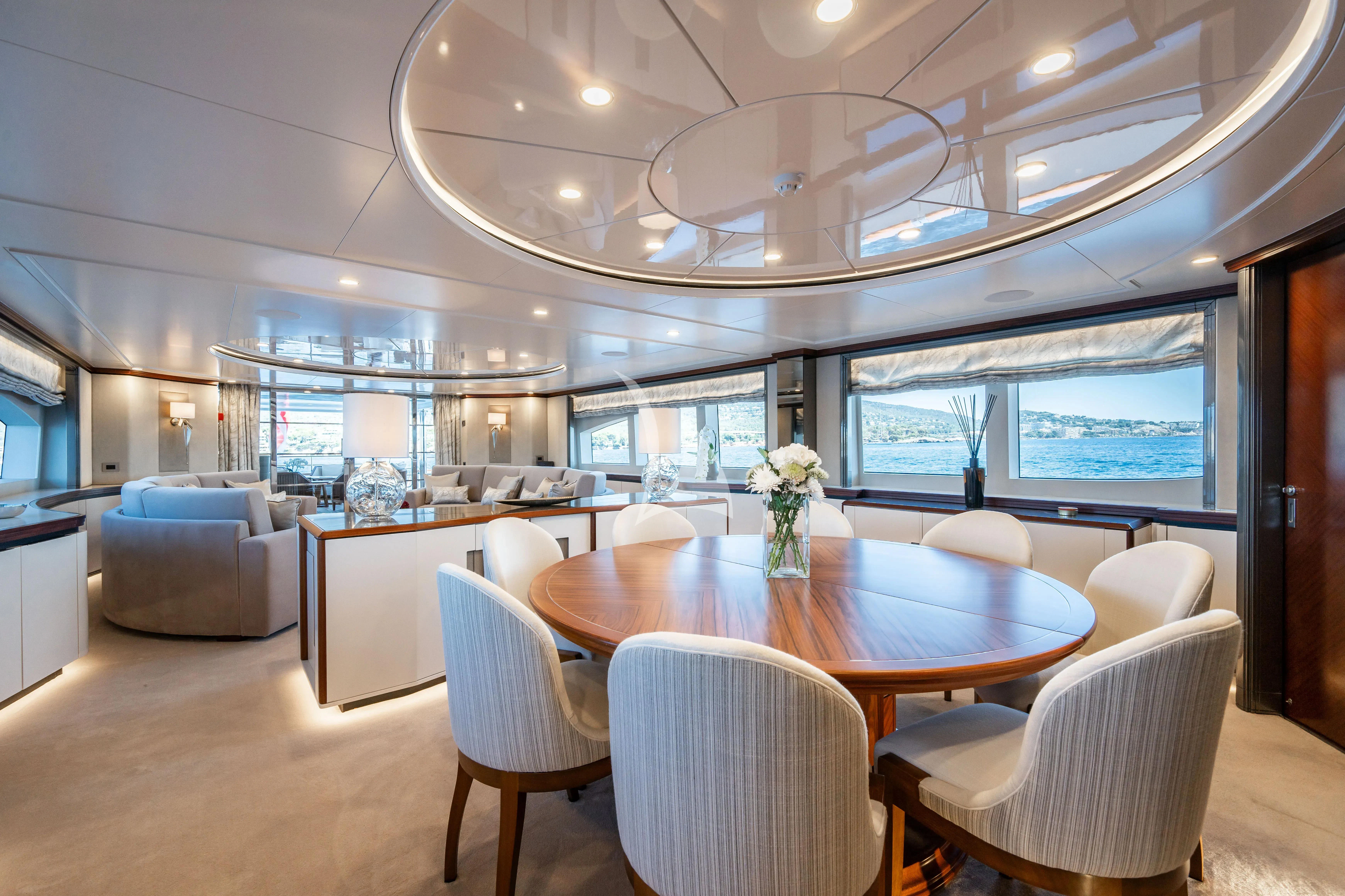 a large room with a table and chairs aboard TITIAN PEARL Yacht for Sale