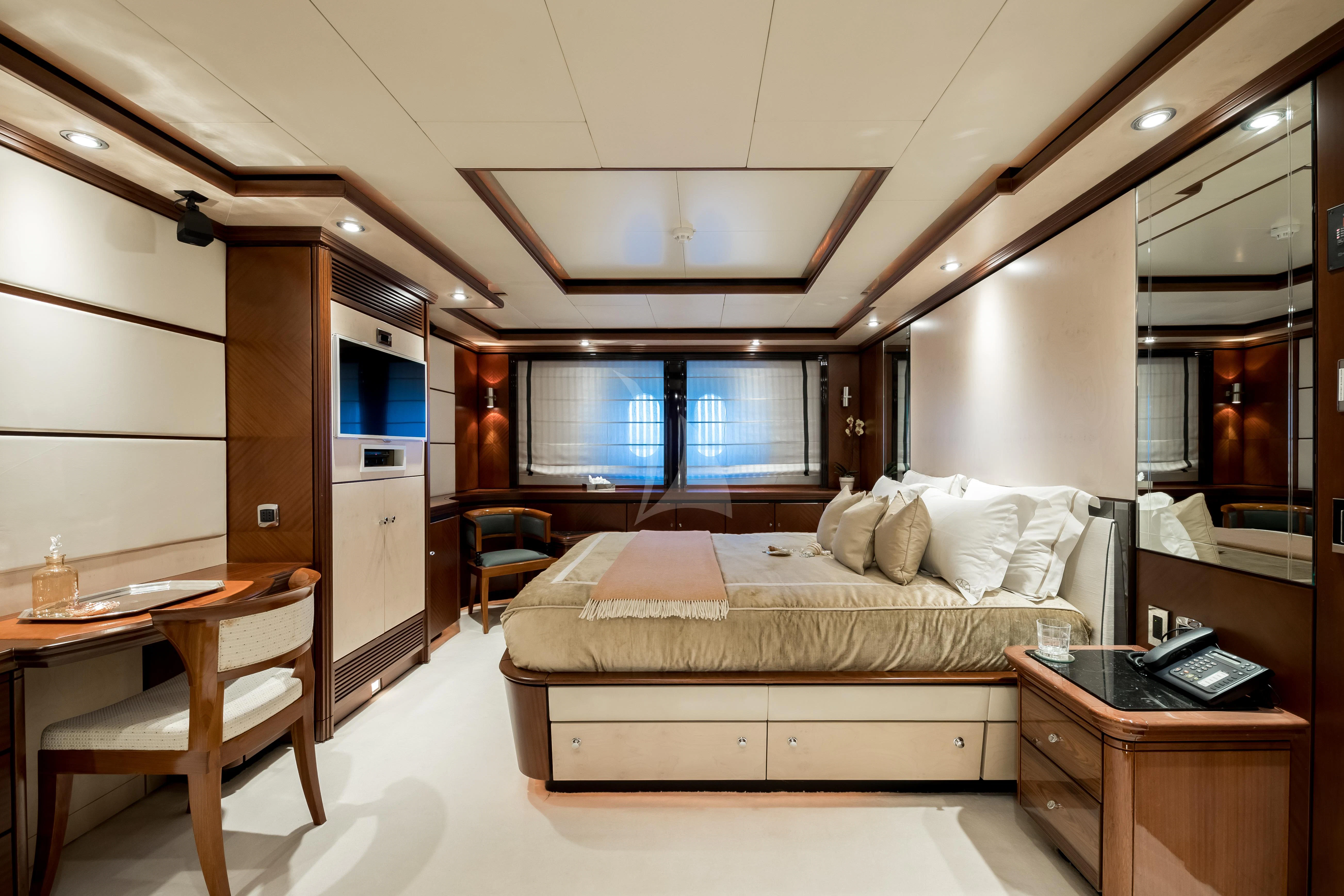 a bedroom with a bed and desk aboard TITIAN PEARL Yacht for Sale
