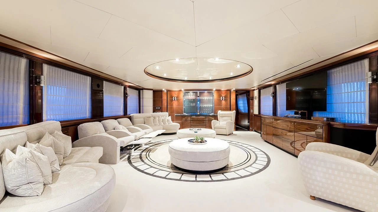 a large white room with a round table and white chairs aboard TITIAN PEARL Yacht for Sale