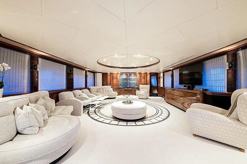 a large white room with a round table and white couches aboard TITIAN PEARL Yacht for Sale