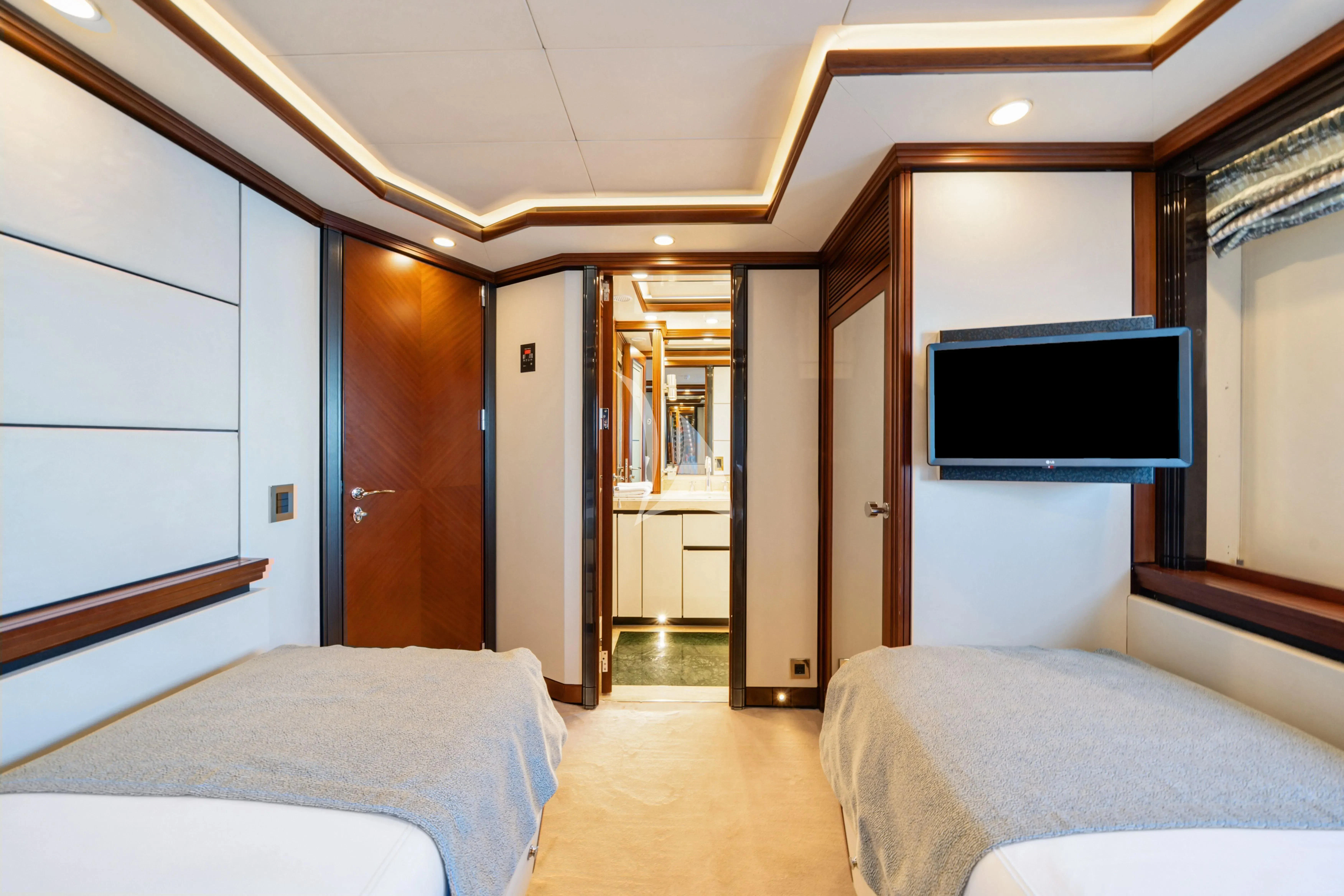 a bedroom with a bed and a tv aboard TITIAN PEARL Yacht for Sale