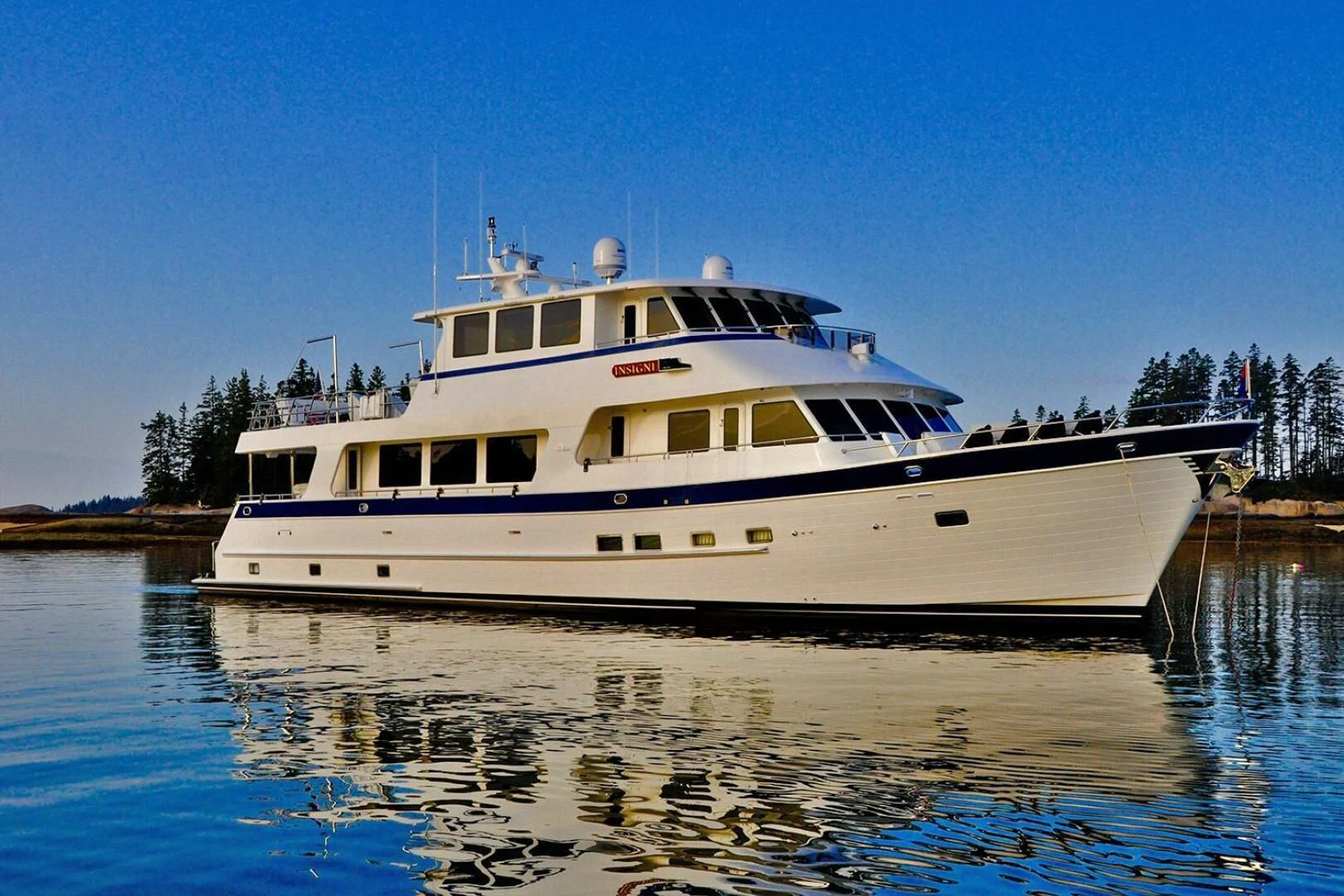 a large white boat on the water aboard INSIGNIA Yacht for Sale