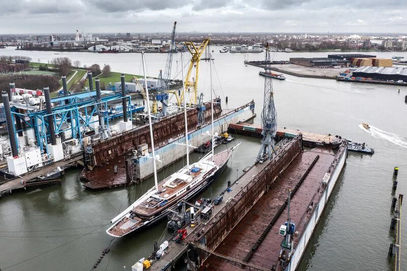 a large cargo ship in a harbor aboard KORU Yacht for Sale