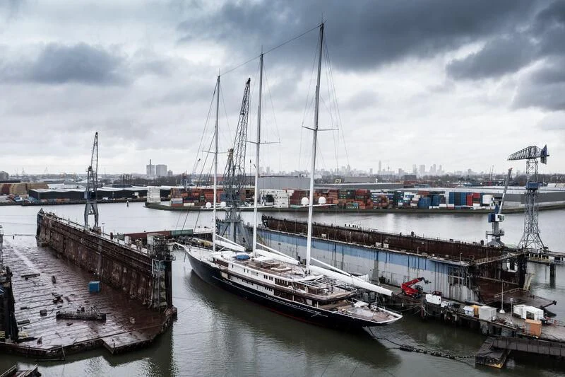 a large ship docked at a pier aboard KORU Yacht for Sale
