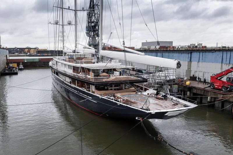 a large boat docked at a pier aboard KORU Yacht for Sale