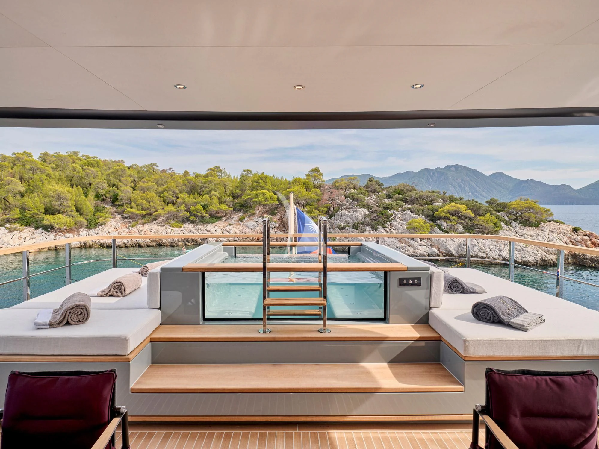 a deck with a view of a mountain range and a lake aboard PARA BELLVM Yacht for Charter